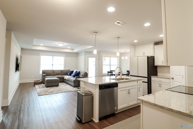 kitchen with dishwasher, white cabinets, sink, hanging light fixtures, and an island with sink