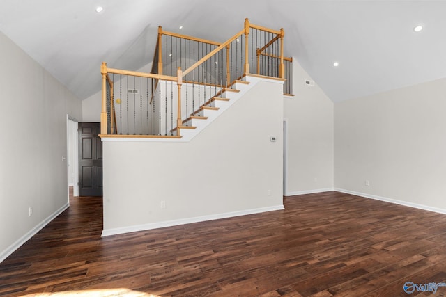 unfurnished living room featuring dark wood-style floors, baseboards, and high vaulted ceiling