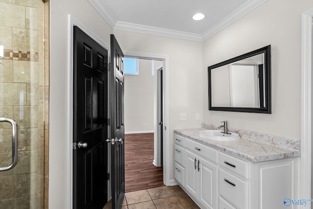 full bath featuring crown molding, a shower stall, vanity, baseboards, and tile patterned floors