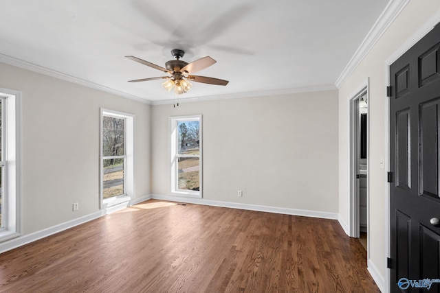 empty room with baseboards, dark wood-style flooring, and crown molding