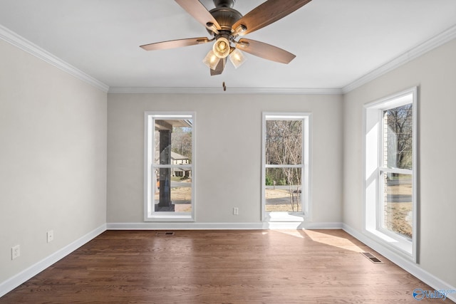 empty room featuring crown molding, dark wood finished floors, baseboards, and a ceiling fan