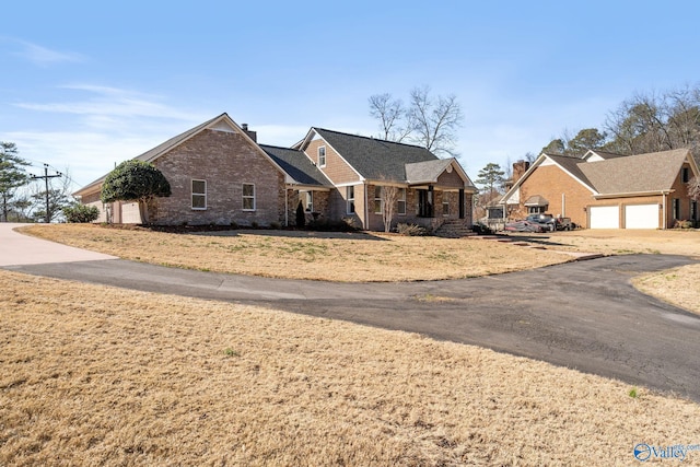 view of front of house featuring a garage, brick siding, and a front lawn