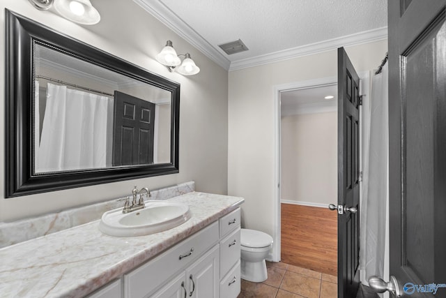 full bathroom featuring a textured ceiling, vanity, crown molding, and tile patterned floors