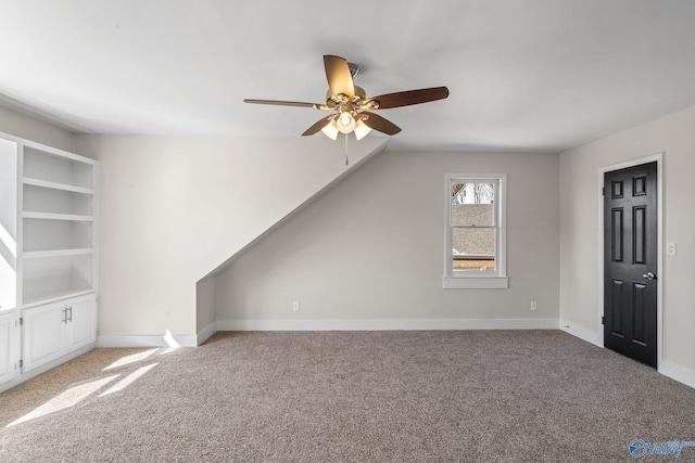 bonus room with light carpet, ceiling fan, and baseboards