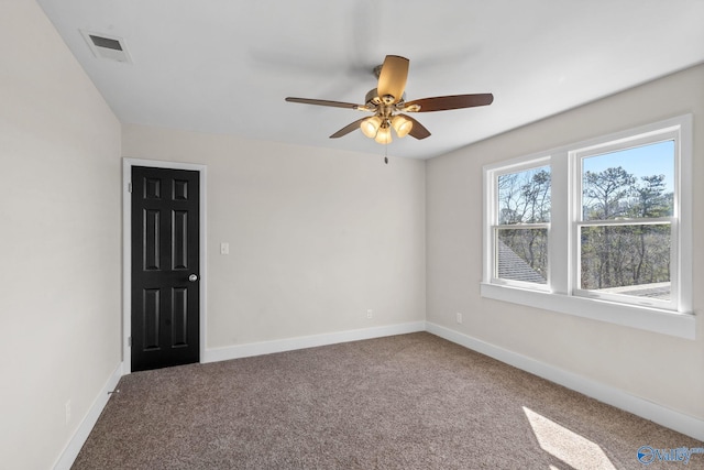 carpeted empty room with visible vents, ceiling fan, and baseboards
