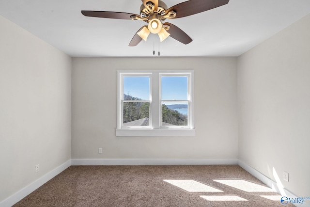 carpeted spare room featuring baseboards