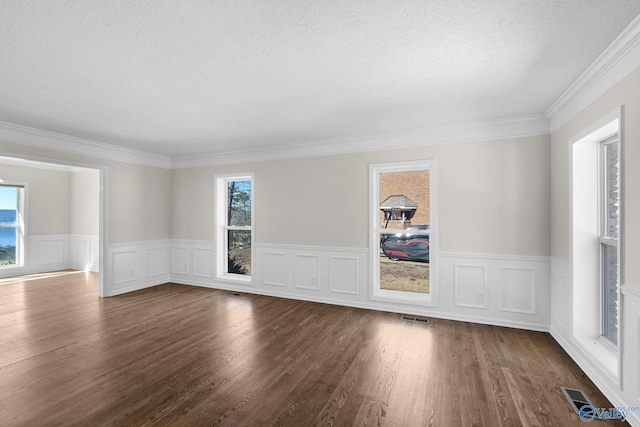 empty room with dark wood-style flooring, visible vents, crown molding, and a textured ceiling