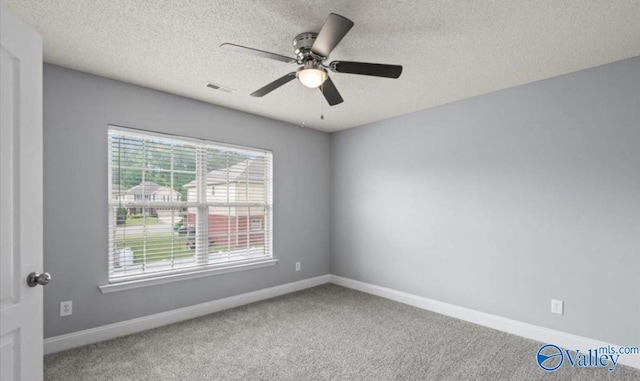 spare room with ceiling fan, carpet, and a textured ceiling