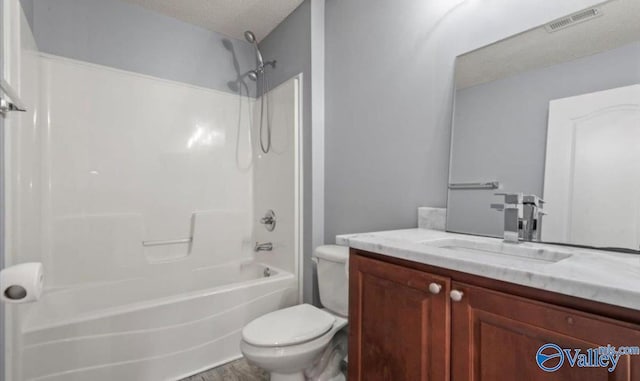 full bathroom featuring vanity, hardwood / wood-style floors, a textured ceiling, toilet, and shower / bathing tub combination