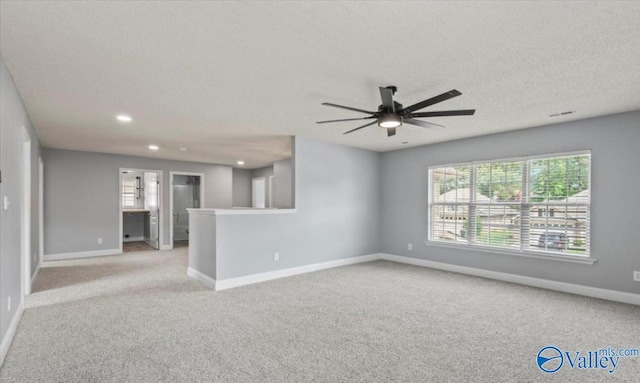 carpeted spare room with a textured ceiling and ceiling fan