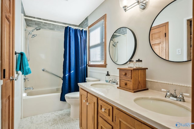 full bath with toilet, shower / bathtub combination with curtain, double vanity, and a sink