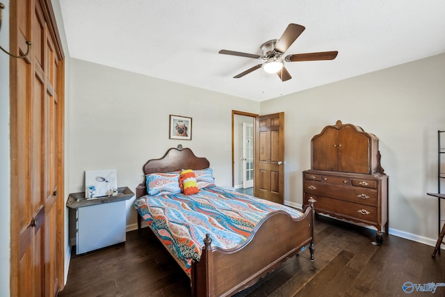 bedroom with a closet, dark wood finished floors, baseboards, and ceiling fan