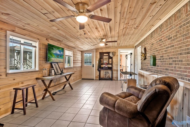 living area with plenty of natural light, wooden walls, brick wall, wood ceiling, and light tile patterned flooring