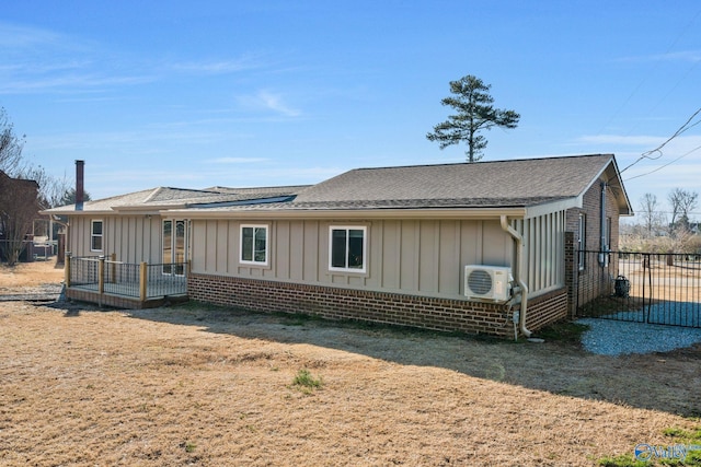 view of front of home with ac unit, brick siding, board and batten siding, and fence