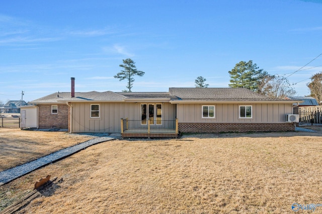 ranch-style home with brick siding, fence, roof with shingles, board and batten siding, and a front yard