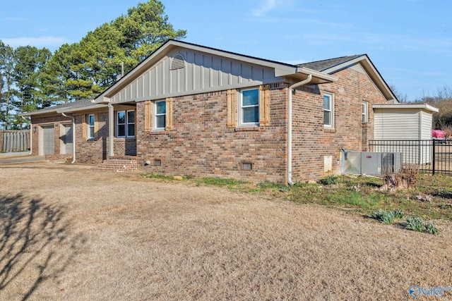 view of home's exterior with a garage, brick siding, crawl space, and board and batten siding