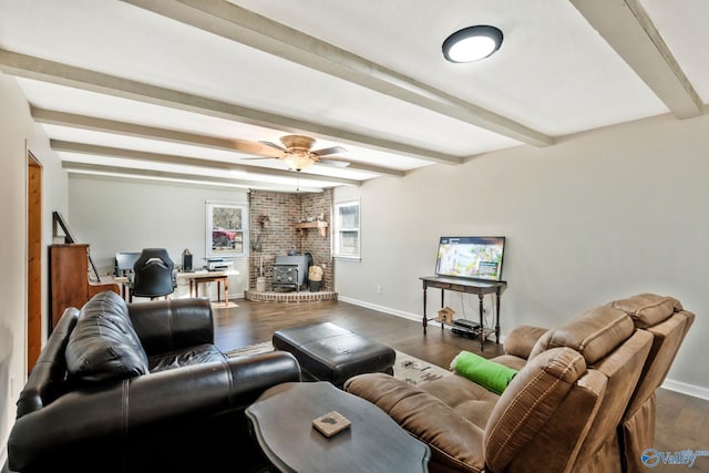 living room featuring a wood stove, dark wood-type flooring, beam ceiling, and baseboards