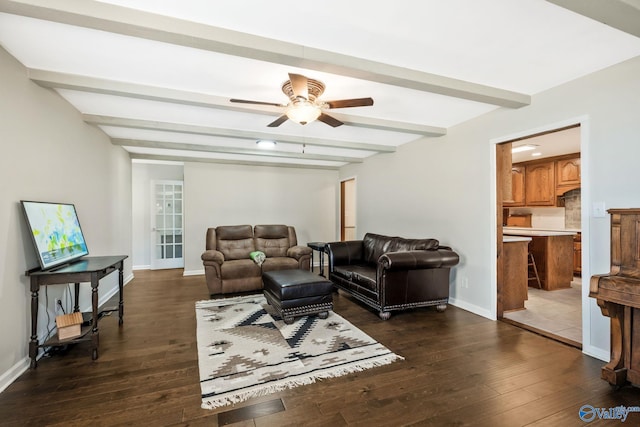 living room with ceiling fan, beamed ceiling, dark wood-style flooring, and baseboards