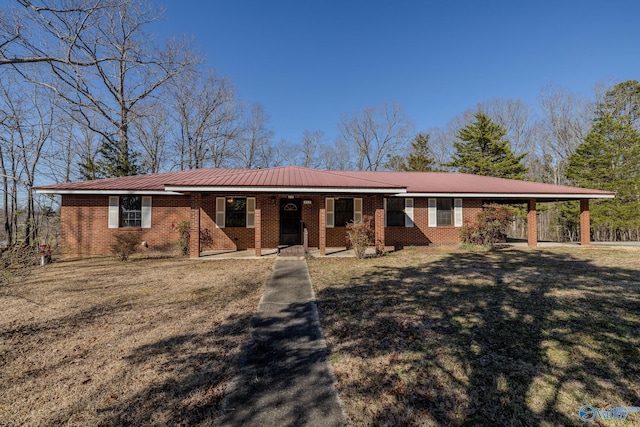 ranch-style house featuring brick siding, a front lawn, a porch, metal roof, and a carport