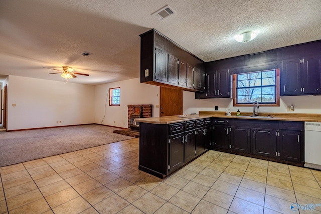 kitchen featuring visible vents, white dishwasher, ceiling fan, a sink, and light countertops