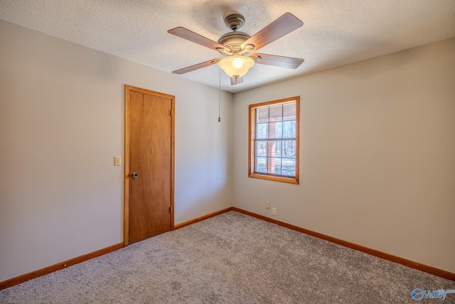 carpeted spare room featuring a textured ceiling, baseboards, and a ceiling fan