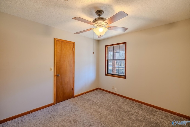 carpeted spare room with ceiling fan, a textured ceiling, and baseboards