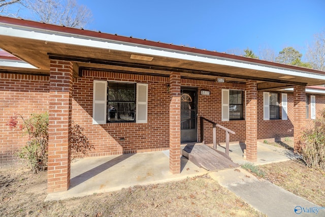 doorway to property featuring brick siding