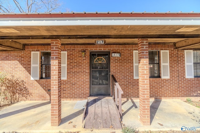 view of exterior entry featuring brick siding