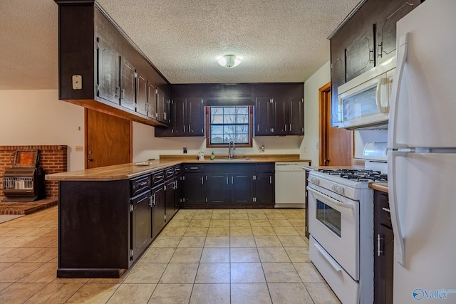 kitchen featuring white appliances, light tile patterned floors, light countertops, and a sink