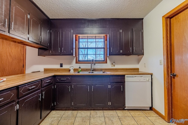 kitchen with light countertops, light tile patterned floors, white dishwasher, a textured ceiling, and a sink