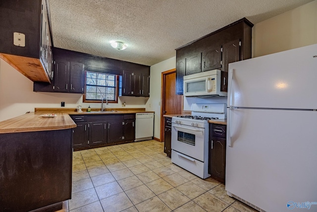 kitchen with a sink, white appliances, dark brown cabinetry, and a textured ceiling