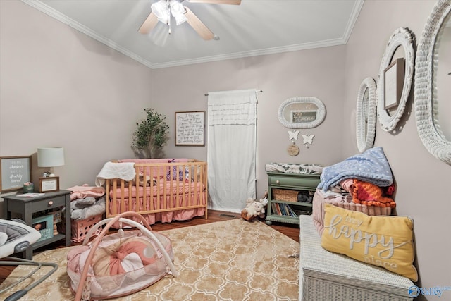 bedroom featuring ceiling fan, ornamental molding, and wood-type flooring