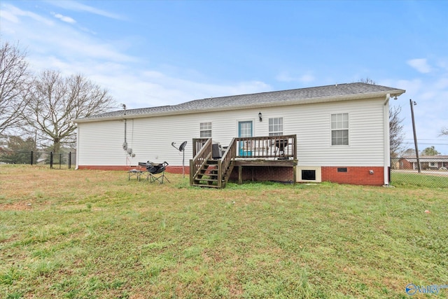 back of property with a wooden deck and a yard