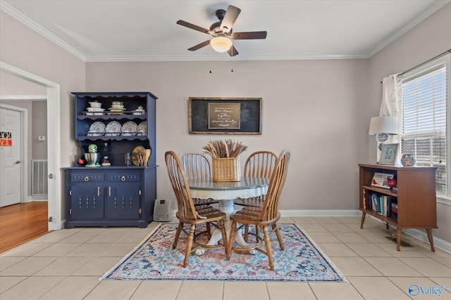 dining area with crown molding, ceiling fan, and light tile patterned floors