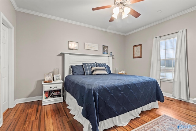 bedroom featuring hardwood / wood-style flooring, ornamental molding, and ceiling fan