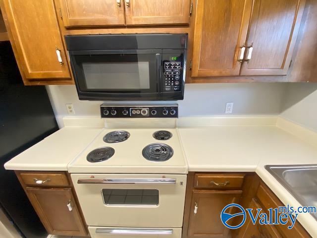 kitchen featuring white electric range and sink