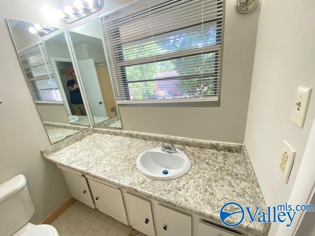 bathroom featuring vanity, tile patterned flooring, and toilet