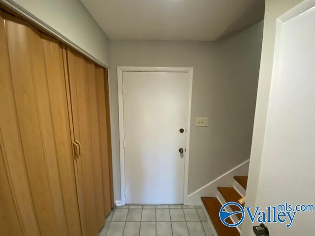 doorway to outside with light tile patterned floors