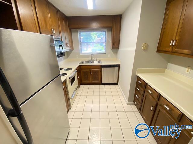 kitchen with sink, appliances with stainless steel finishes, and light tile patterned floors