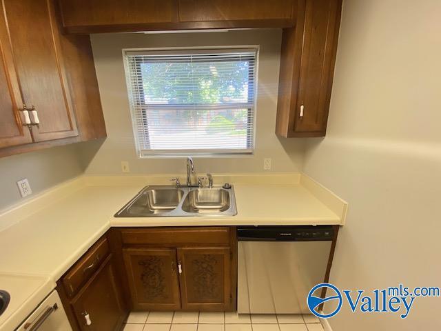 kitchen featuring light tile patterned floors, sink, and stainless steel dishwasher