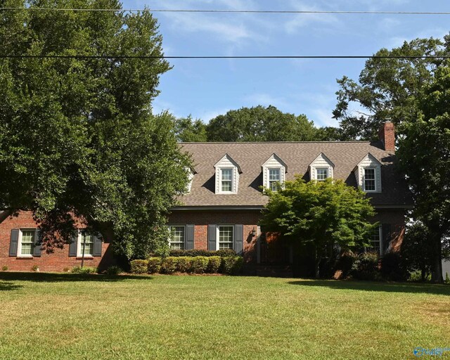 cape cod house featuring a front lawn