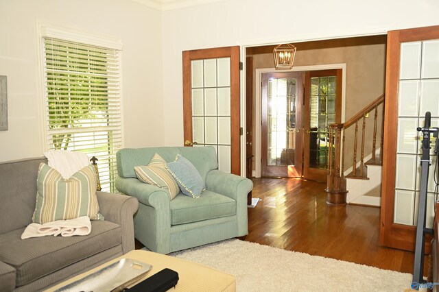 living room featuring french doors, crown molding, and wood-type flooring