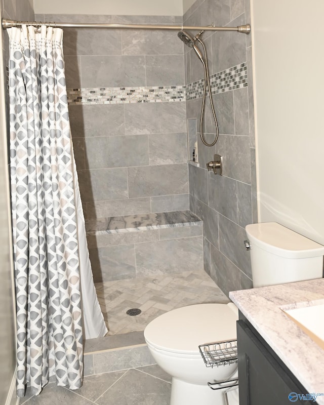 bathroom featuring walk in shower, toilet, tile patterned floors, and vanity