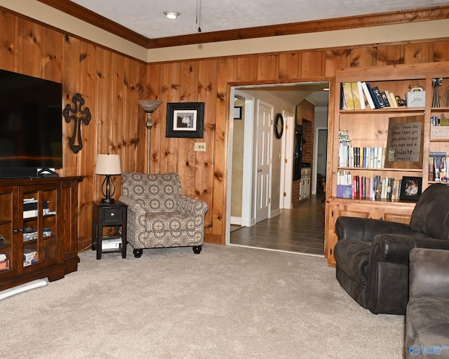 carpeted living room featuring wood walls and ornamental molding