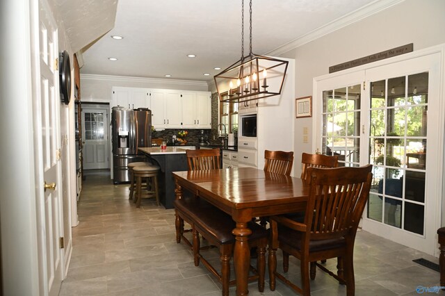 tiled dining room with a notable chandelier and crown molding