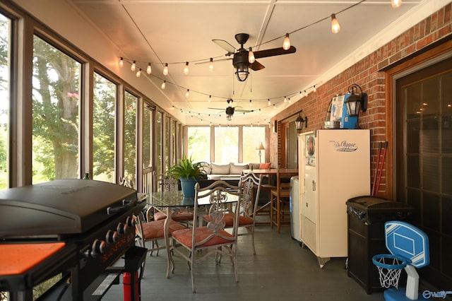 sunroom / solarium with ceiling fan, a wealth of natural light, and track lighting