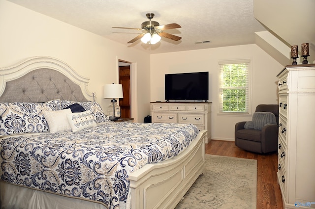 bedroom featuring ceiling fan, a textured ceiling, and hardwood / wood-style floors