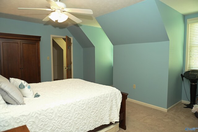 bedroom featuring light carpet, lofted ceiling, and ceiling fan