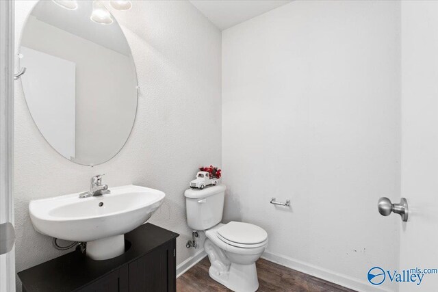 bathroom featuring vanity, hardwood / wood-style flooring, and toilet