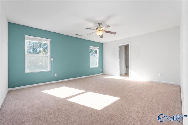 carpeted spare room with ceiling fan and a healthy amount of sunlight